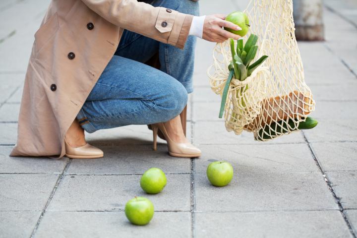 Una persona, recogiendo manzanas del suelo.
