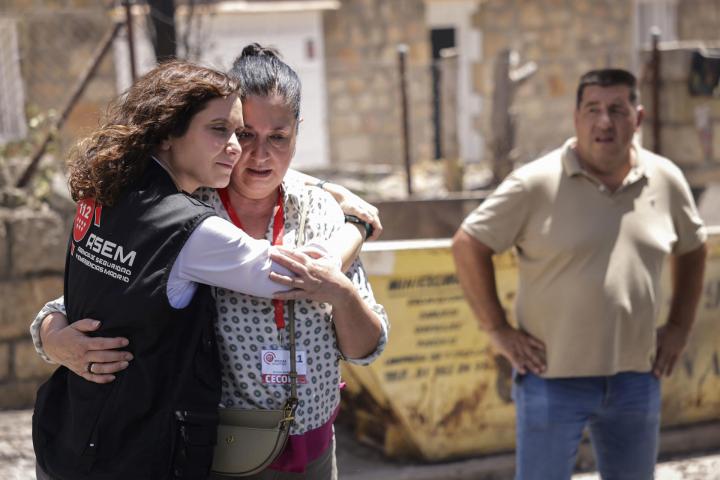 La presidenta de la Comunidad de Madrid, Isabel Díaz Ayuso (i), abraza a una afectada por los incendios en la urbanización El Encinar del Alberche, en Villa del Prado
