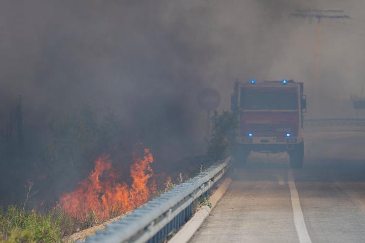 Un camión de bomberos pasando al lado de un incendio