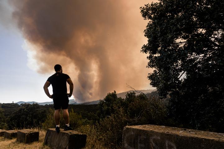 Un vecino observa el avance del fuego del incendio forestal de San Martín de Valdeiglesias, en Madrid