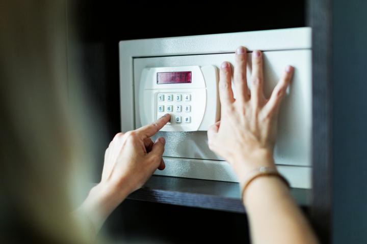 Una mujer pone la clave de su caja fuerte.