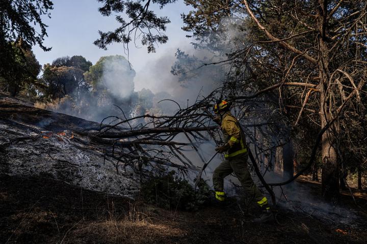 Un bombero trata de controlar un punto caliente en la Sierra Oeste de Madrid