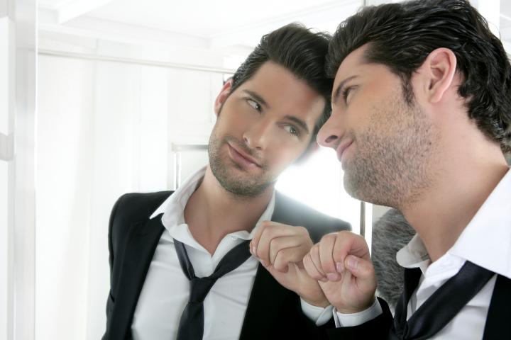Un hombre, gustándose ante un espejo.