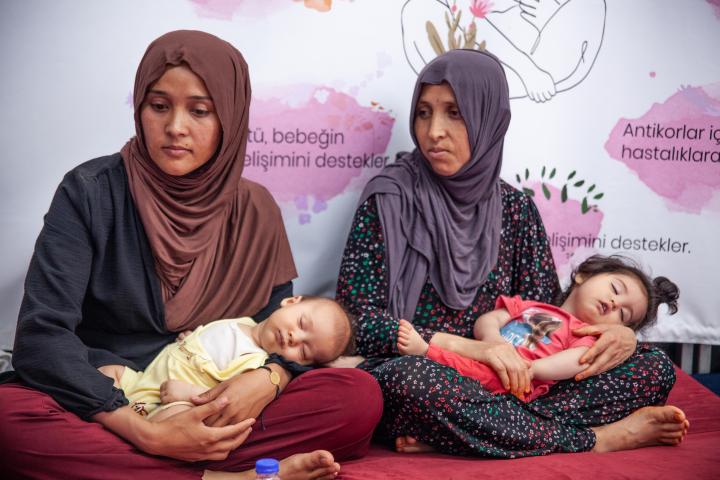 Dos madres uzbekas atienden a sus bebés en una zona de asistencia de Acción contra el Hambre tras los terremotos de Turquía de 2023, en Ovakent (Hatay).