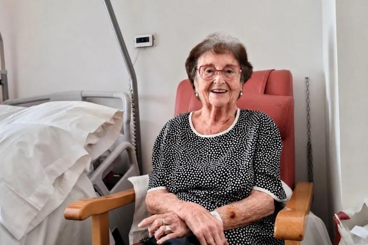 Una anciana recostada en una butaca junto a una cama de hospital mira sonriente a cámara: es Rosita Rochina