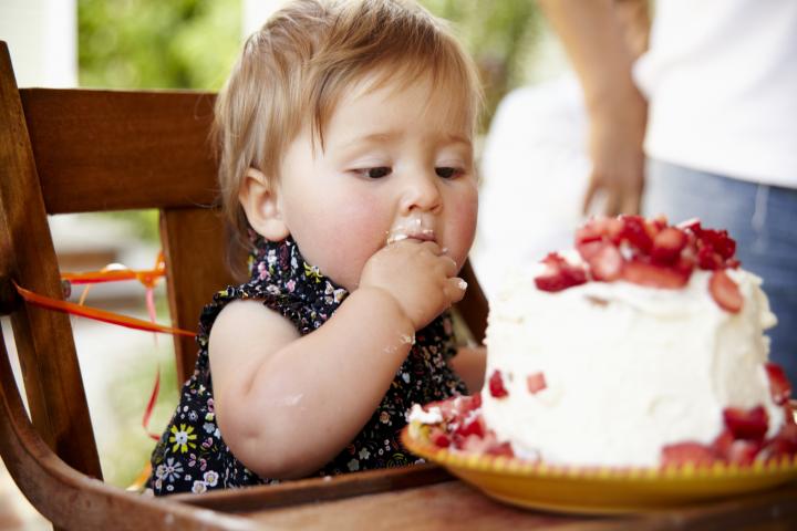 Una bebé come con las manos un trozo de tarta, en una imagen de archivo.