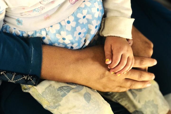 Una madre sostiene a su hija en uno de los "Espacios Seguros para Bebés" que Acción contra el Hambre mantiene en Gaza.