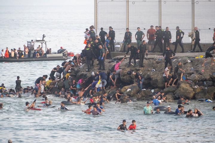Cientos de personas de origen magrebí cruzan a Ceuta desde Marruecos, ya sea nadando o escalando el rompeolas, el 30 de julio de 2026.