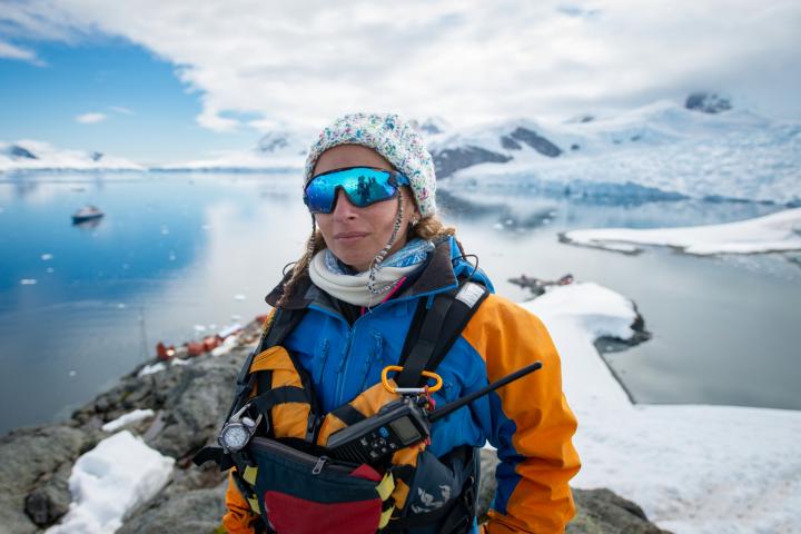 Retrato de un guía de expediciones polares en la costa, sobre una bahía glaciar y montañas nevadas