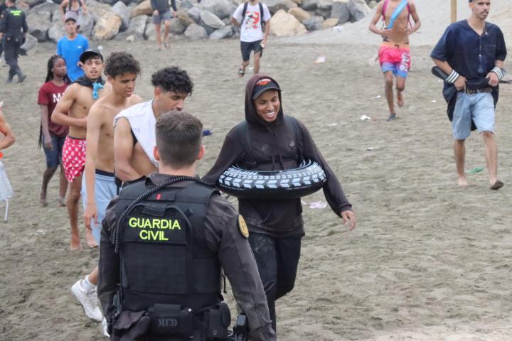 Un grupo de inmigrantes en la playa junto al paso fronterizo del Tarajal en Ceuta este viernes