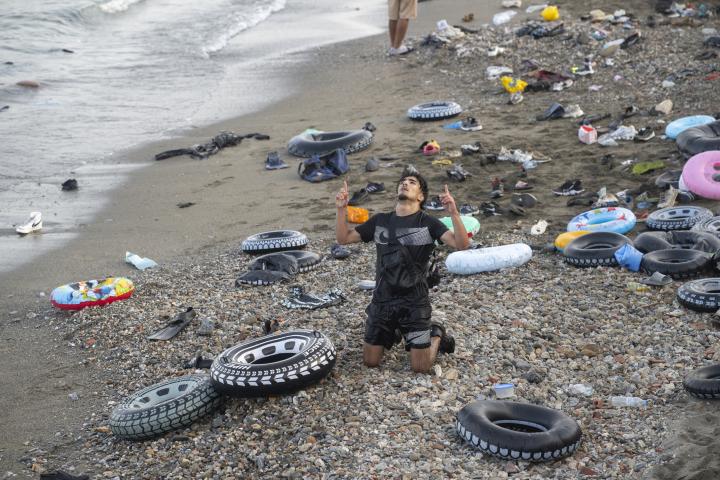 Un hombre celebra haber conseguido cruzar a España en la playa ceutí del Tarajal