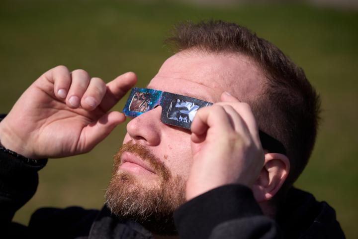 Un hombre viendo un eclipse solar con unas gafas homologadas