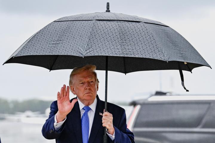 El presidente de EEUU, Donald Trump, sostiene un paraguas tras desembarcar del Air Force One en la Base Conjunta Andrews (Maryland, EEUU), el 2 de agosto de 2026.