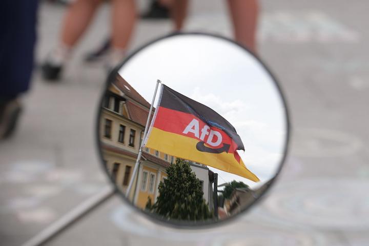 26 July 2026, Saxony-Anhalt, Weißenfels: A German flag bearing the AfD logo can be seen in the rearview mirror of a moped. AfD lead candidate Siegmund is on a campaign tour through Saxony-Anhalt ahead of the state election. Photo: Sebastian Willnow/dpa (Photo by Sebastian Willnow/picture alliance via Getty Images)