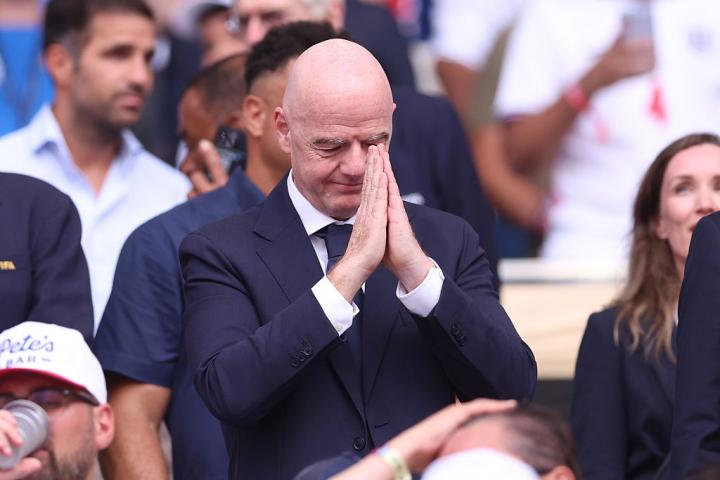 Gianni Infantino simulando rezar en el palco