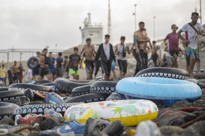 Migrantes que han cruzado a nado la frontera de Ceuta desde Marruecos, en la playa de El Tarajal.