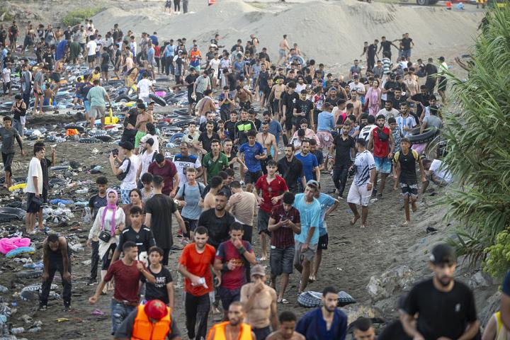 Un grupo de personas camina hacia el casco urbano de Ceuta, tras cruzar desde Marruecos por la zona del Tarajal, el 30 de julio de 2026.