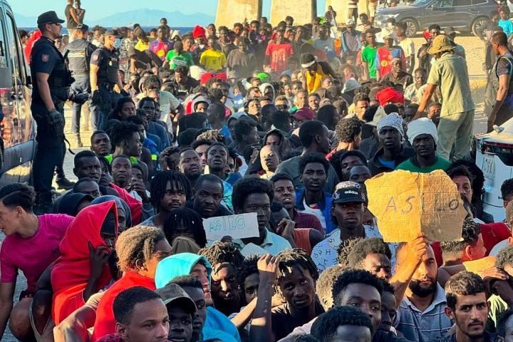 La Cruz Roja y la organización Sur Sur distribuyen alimentos básicos entre los migrantes que cruzaron a Ceuta, ante la mirada de la Policía, el 3 de agosto de 2026.