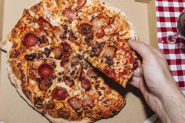 Una persona, comiendo una pizza.