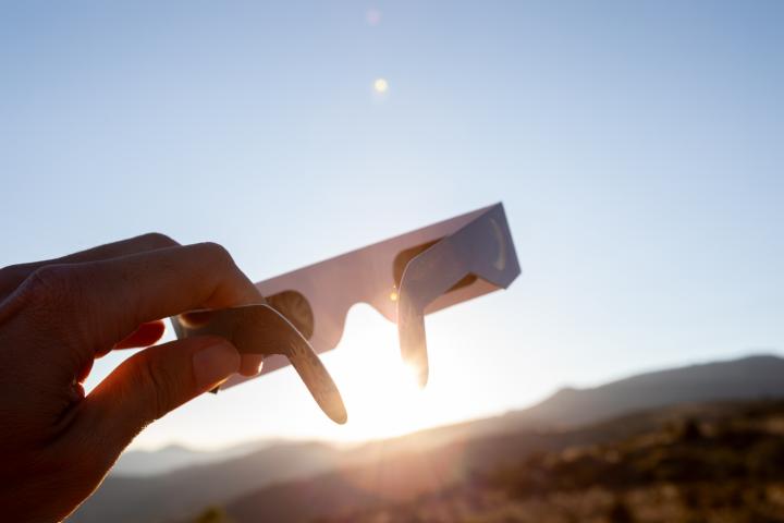 Una persona sujeta las gafas para ver el eclipse.