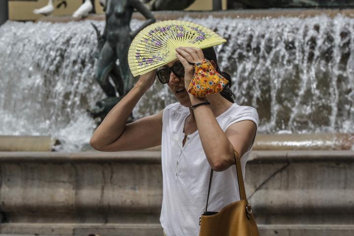 Una mujer paseando con un abanico