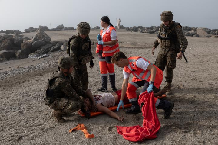 Sid Ahmed Dib, algerino de 23 años, es ayudado por soldados españoles y la Cruz Roja, tras cruzar a nado la frontera hasta la playa de El Tarajal (Ceuta).