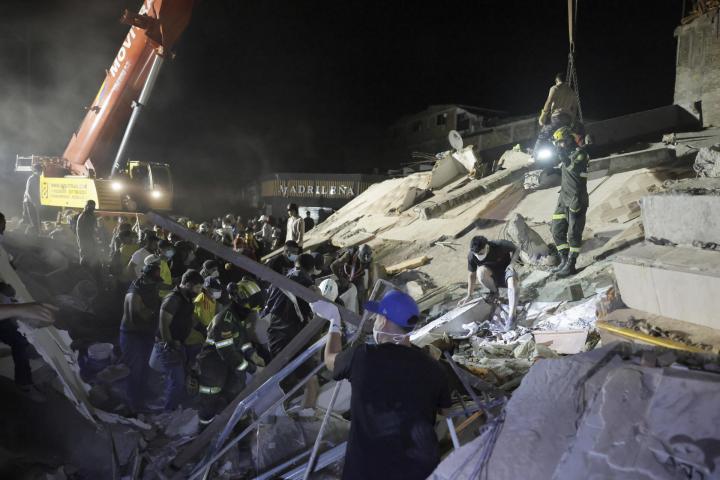 Integrantes de la Policía de Búsqueda y Rescate y vecinos quitan escombros en un edificio hundido por el terremoto en Pereira (Colombia), el 11 de agosto de 2026.