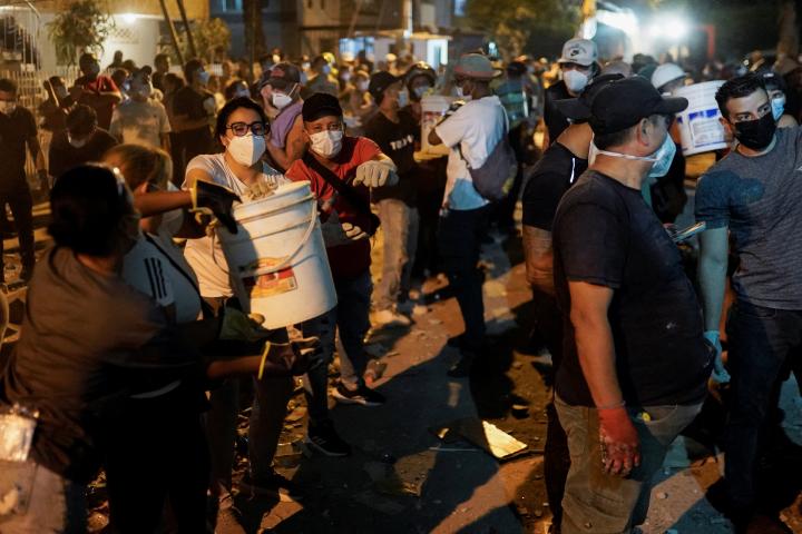 Rescatistas y civiles trabajan al pie de un edificio derrumbado tras un terremoto en Cali, (Colombia), el 10 de agosto de 2026.