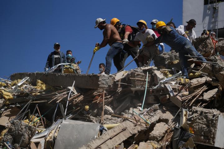 Un grupo de personas trabajan en labores de rescate en una edificación colapsada por el terremoto de magnitud 7,4 que sacudió Colombia, en Cali, el 10 de agosto de 2026.