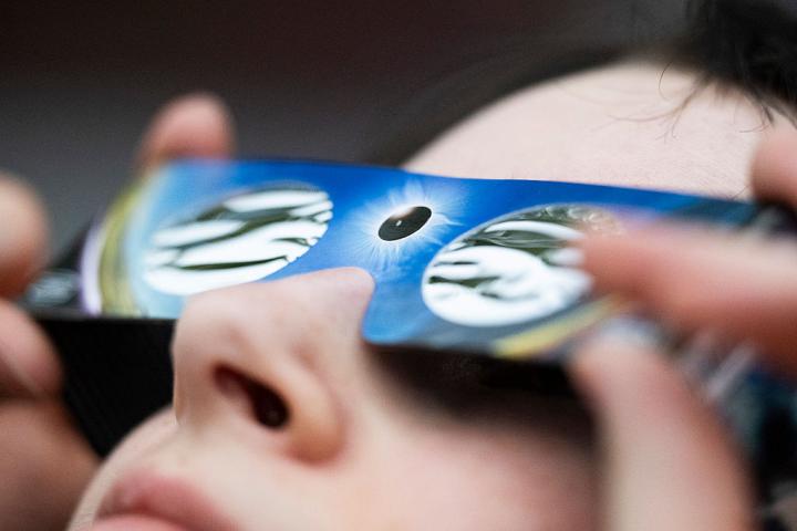Una mujer lleva gafas para ver un eclipse solar