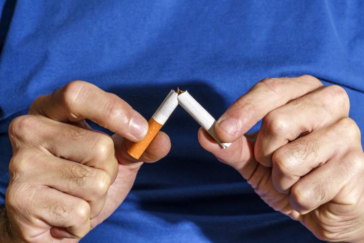 Una persona rompiendo un cigarrillo