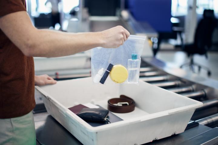 Una persona, con su bolsa de líquidos en un aeropuerto.