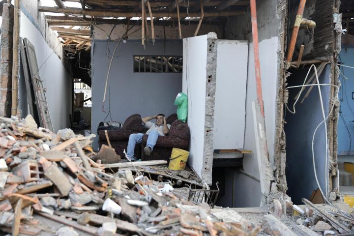 Una persona espera junto a los escombros de una vivienda este martes, en el sector de Corocito en Pereira (Colombia)