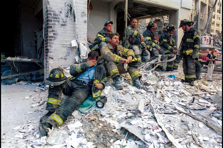 Un grupo de bomberos descansa entre los escombros tras trabajar toda la noche, la mañana siguiente a los ataques terroristas del 11 de septiembre de 2001, en Nueva York.