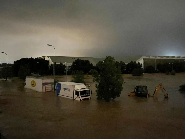 Camiones y un vehículo de construcción parcialmente sumergidos en las inundaciones que han tenido lugar en la provincia de Valencia