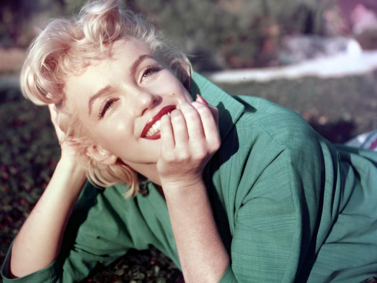 La actriz Marilyn Monroe posa para un retrato tumbada sobre la hierba en 1954 en Palm Springs, California.