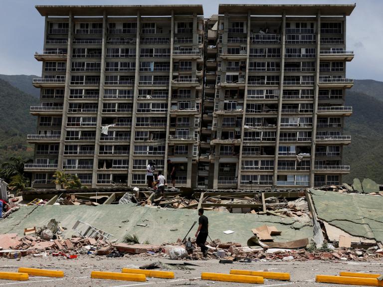 Un grupo de personas inspeccionan los escombros de un edificio dañado tras los terremotos que azotaron el país, en La Guaira (Venezuela), el 25 de junio de 2026.