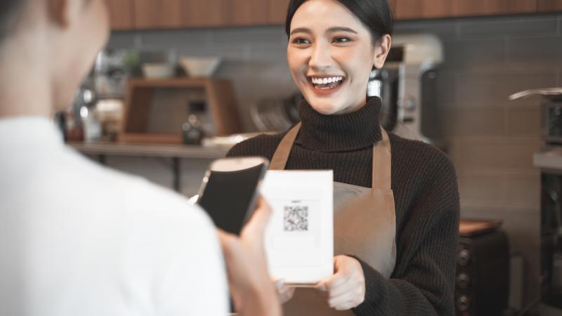 Un cliente escanea el QR de la carta de una cafetería.