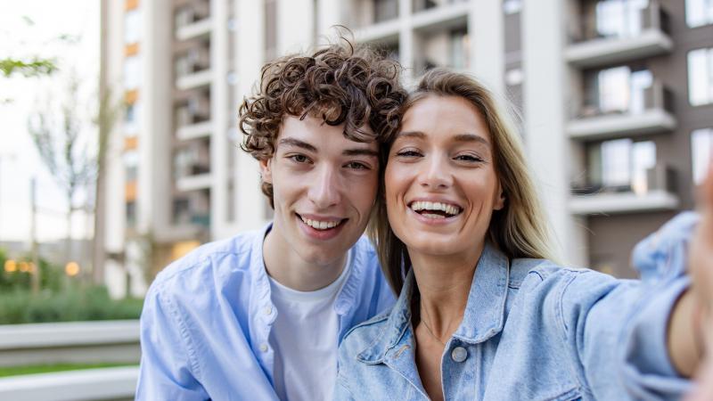 Una pareja sonriente tirándose un selfie.
