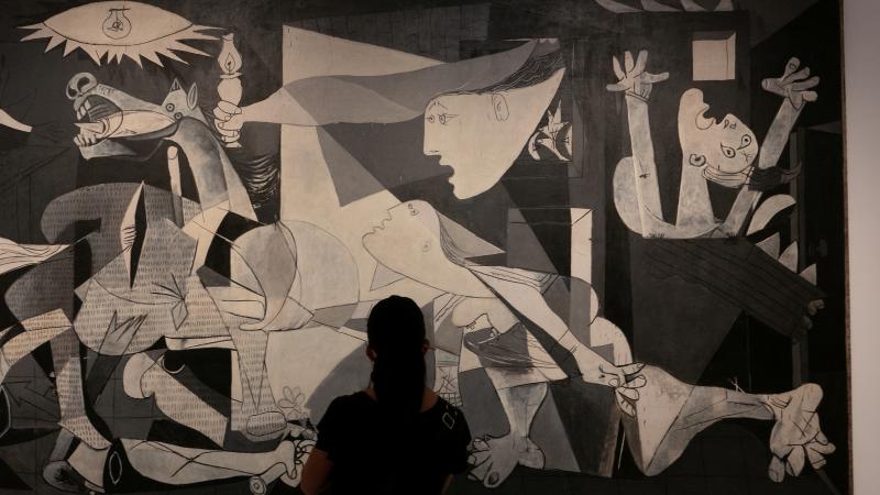 Una mujer viendo el Guernica de Picasso.