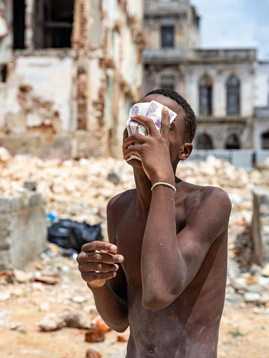 Un joven cubierto de polvo de cal y sudor sostiene billetes mientras descansa de la limpieza de escombros de un local derrumbado en La Habana (Cuba), el 11 de junio de 2026.
