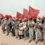 Un grupo de marroquíes con banderas nacionales y retratos del rey Hassan II, avanza hasta el paso del Tah, en la frontera con el Sáhara Occidental, el 6 de noviembre de 1975.