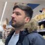 Novio español en un supermercado italiano mirando distintos tipos de pasta mientras su pareja graba.