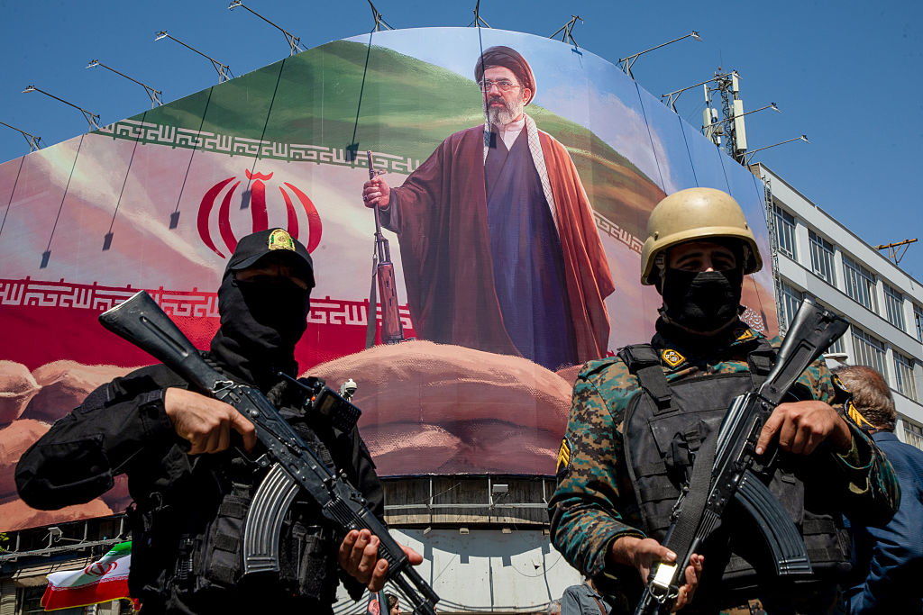 Miembros de las fuerzas de seguridad iraníes montan guardia bajo un gran retrato del nuevo líder supremo, Mojtaba Jamenei, el 9 de abril de 2026, en Teherán.